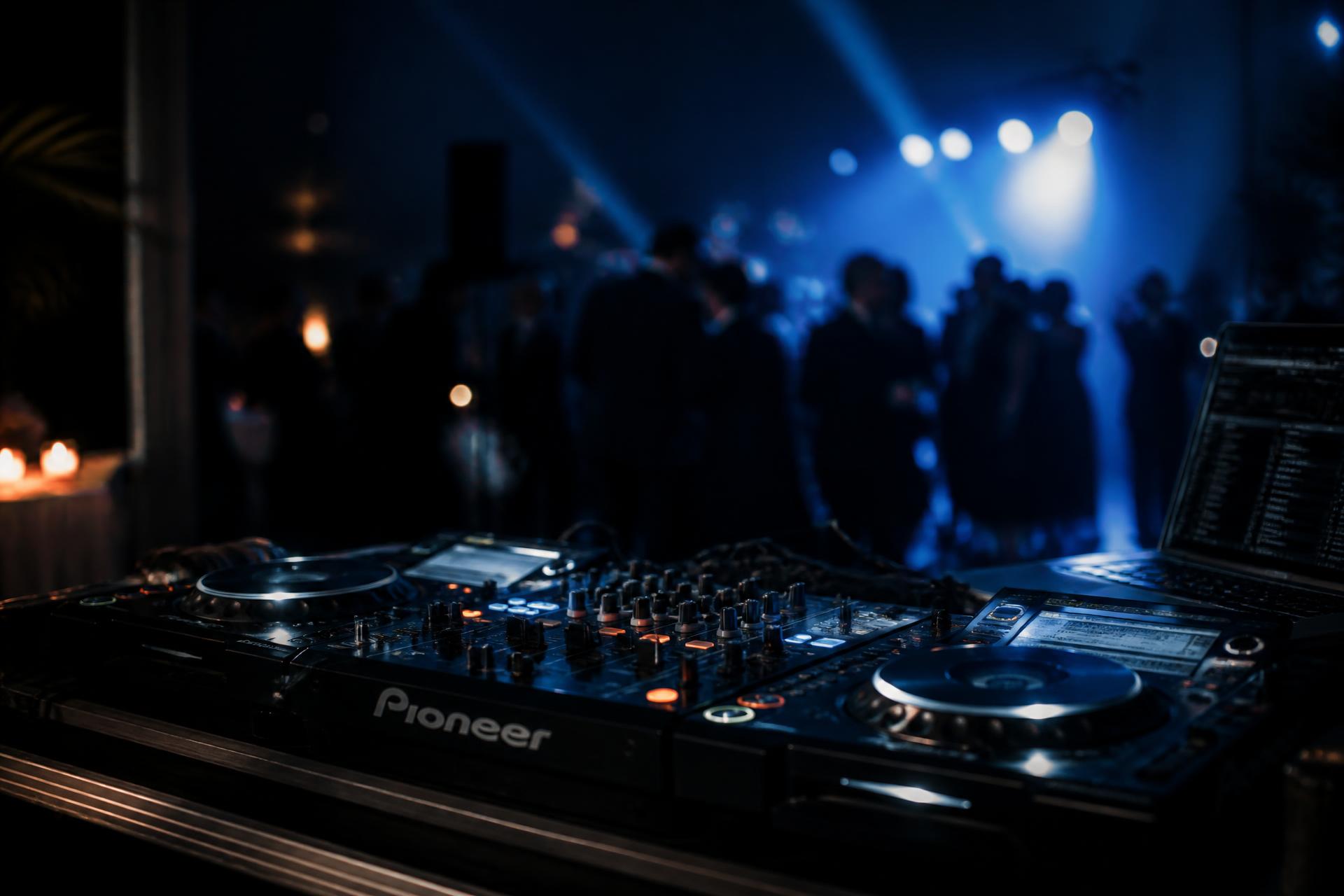 DJ mixer and turntables at a Charlotte, NC event with blue stage lighting